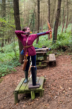 Archer standing in the woodland practice area, poised to take a shot